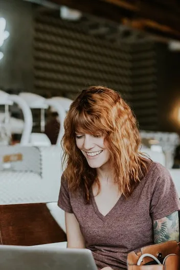 Mulher sorrindo para o computador