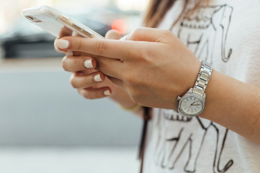 woman holding iPhone during daytime